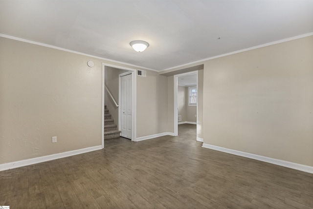 spare room with crown molding, dark wood finished floors, visible vents, baseboards, and stairs