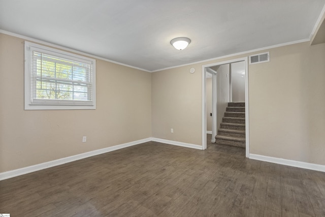 basement with dark wood-style flooring, crown molding, visible vents, baseboards, and stairs