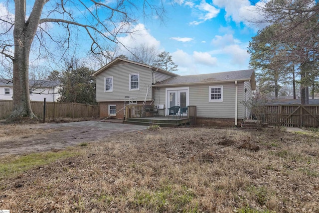 rear view of property with brick siding, fence, a deck, and french doors