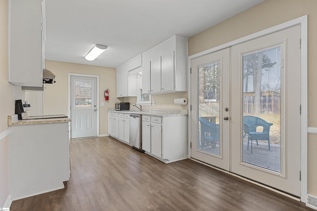 kitchen with french doors, light countertops, stainless steel dishwasher, white cabinetry, and wood finished floors