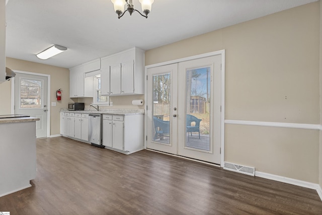 kitchen featuring stainless steel appliances, light countertops, visible vents, dark wood-type flooring, and white cabinetry