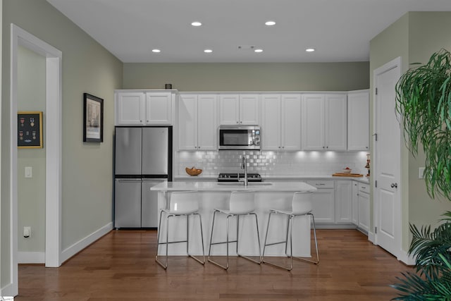 kitchen with white cabinetry, appliances with stainless steel finishes, tasteful backsplash, and light countertops