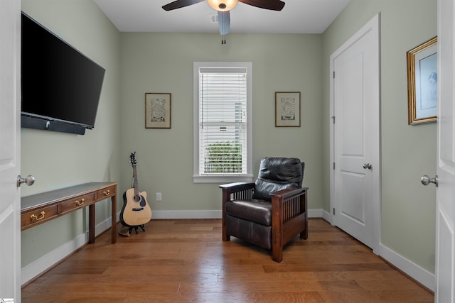 living area featuring light wood finished floors, ceiling fan, and baseboards