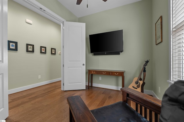 living area with ceiling fan, baseboards, and wood finished floors