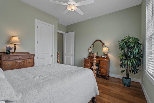 bedroom featuring ceiling fan, wood finished floors, visible vents, and baseboards