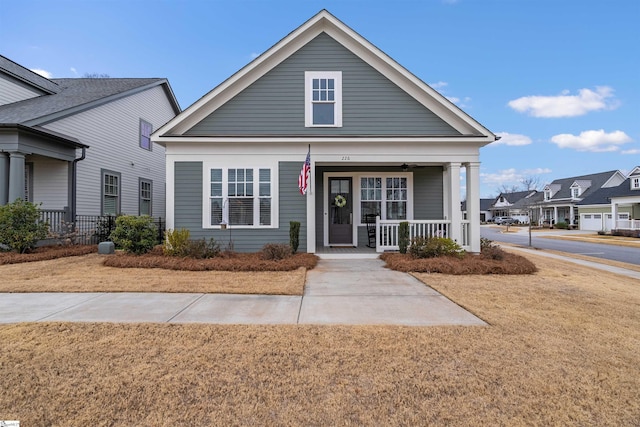 view of front of home with covered porch and a front lawn