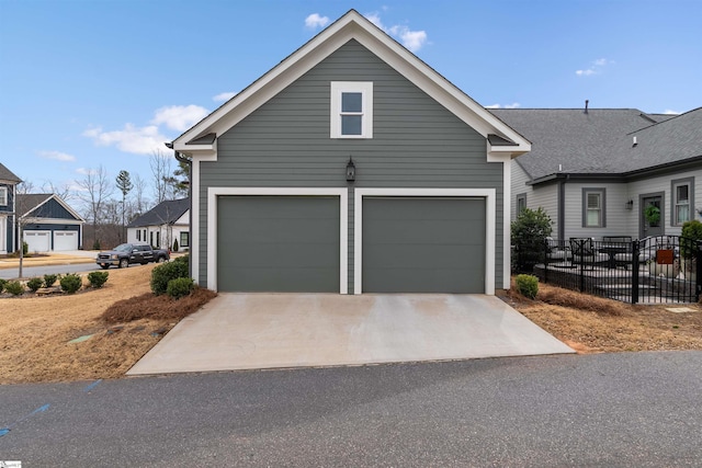 view of front of home featuring driveway, an attached garage, and fence