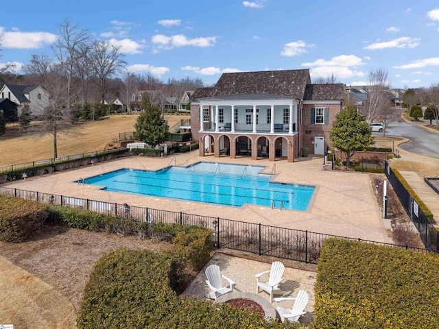 community pool with fence and a patio