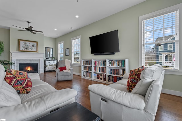 living area featuring recessed lighting, a fireplace, baseboards, and wood finished floors