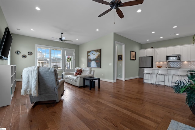 living room with baseboards, dark wood-style flooring, a ceiling fan, and recessed lighting