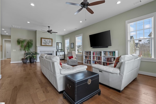 living area featuring recessed lighting, visible vents, and wood finished floors