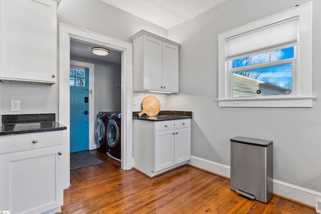 laundry room with baseboards, laundry area, dark wood-type flooring, and washer and dryer