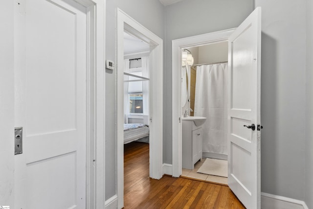 hallway with wood-type flooring and baseboards