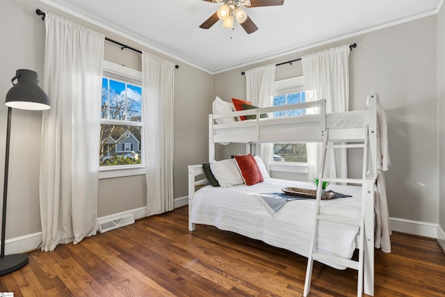 bedroom featuring multiple windows, baseboards, and wood finished floors