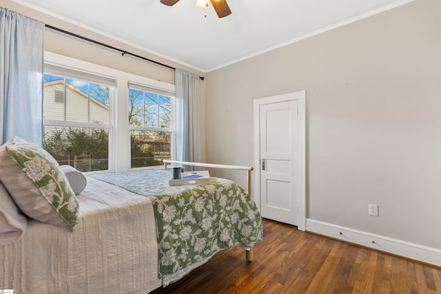 bedroom featuring ceiling fan, baseboards, crown molding, and wood finished floors