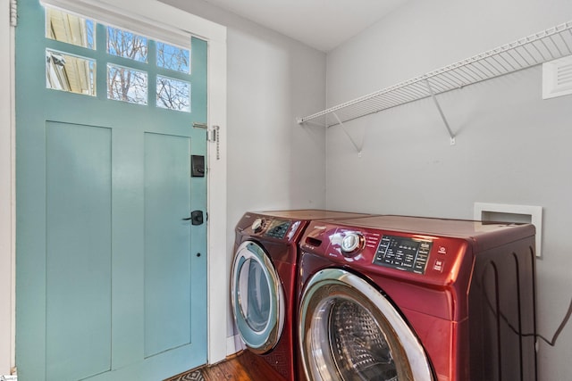 washroom featuring laundry area, wood finished floors, and washer and dryer