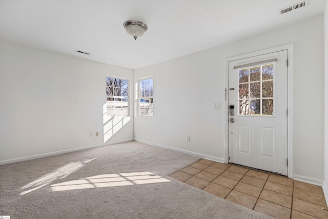 tiled foyer entrance with carpet, visible vents, and baseboards