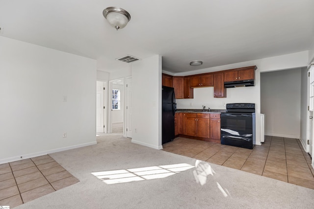 kitchen with under cabinet range hood, light carpet, a sink, visible vents, and black appliances