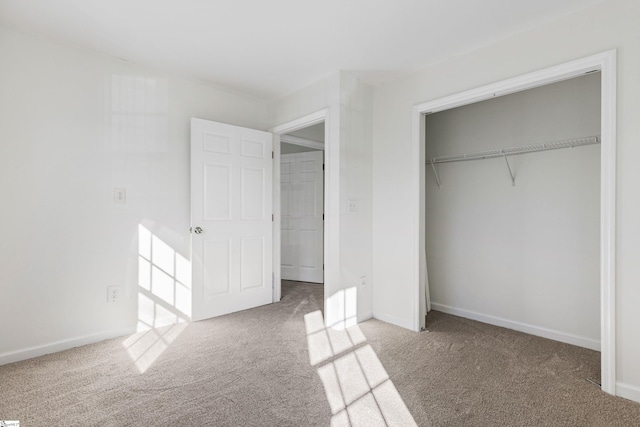 unfurnished bedroom with carpet floors, a closet, and baseboards