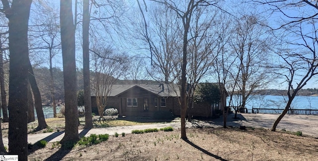 view of property exterior featuring a water view and fence