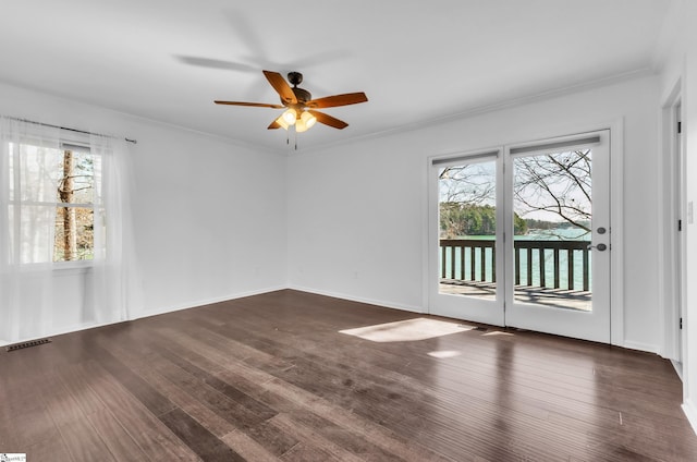 spare room with ceiling fan, wood finished floors, visible vents, and crown molding