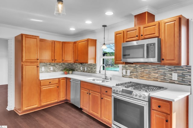 kitchen with ornamental molding, light countertops, appliances with stainless steel finishes, and a sink