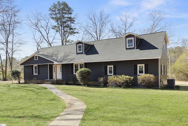 cape cod house featuring a shingled roof, a front yard, and central air condition unit