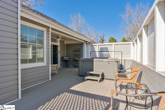 deck featuring a ceiling fan and a hot tub