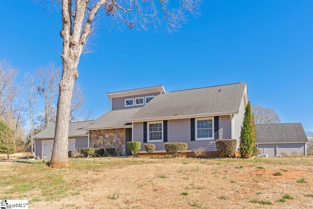 view of front of house featuring stone siding, a front lawn, and roof with shingles