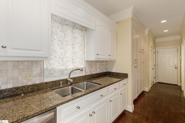 kitchen with dark stone counters, a sink, white cabinets, dishwasher, and dark wood finished floors