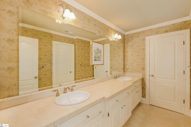 bathroom featuring double vanity, wallpapered walls, crown molding, and a sink