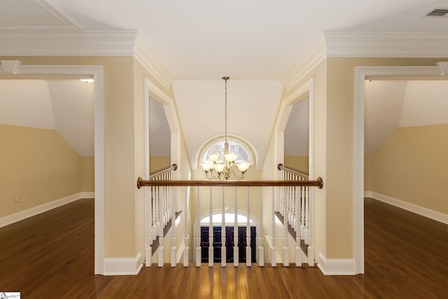 hall with wood finished floors, visible vents, an upstairs landing, and an inviting chandelier