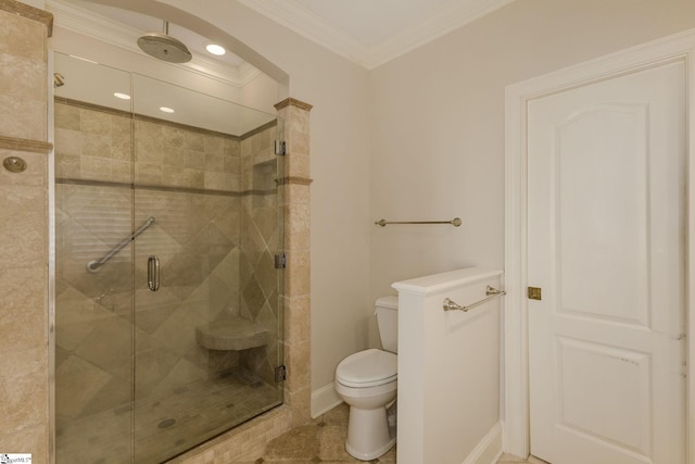 bathroom featuring tile patterned flooring, toilet, baseboards, a shower stall, and crown molding