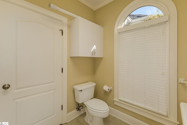 bathroom featuring crown molding, tile patterned flooring, toilet, and baseboards