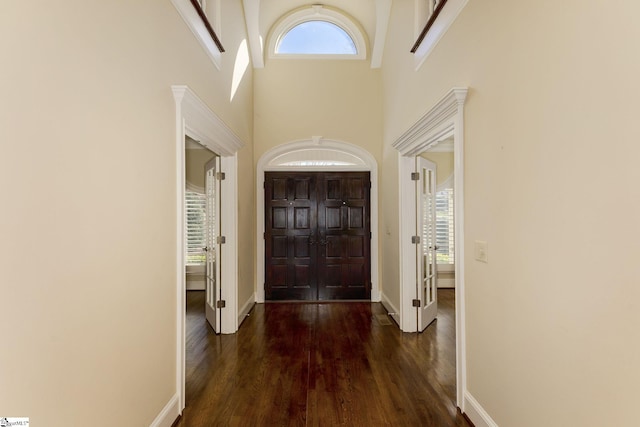 entrance foyer featuring a high ceiling, baseboards, and wood finished floors