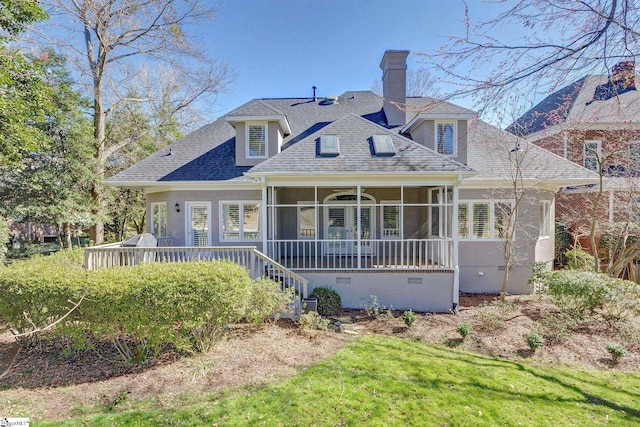 view of front of property with a shingled roof, a sunroom, crawl space, a chimney, and a front yard