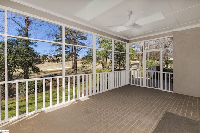 unfurnished sunroom featuring a ceiling fan