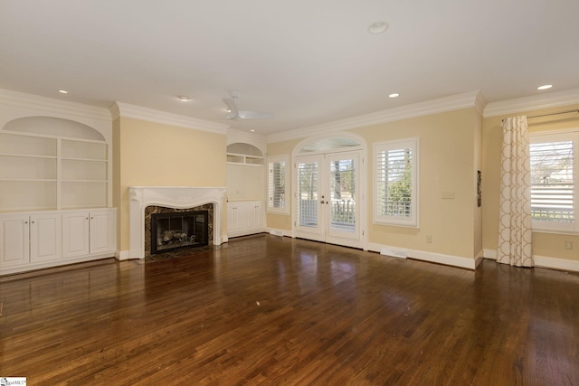 unfurnished living room featuring french doors, wood finished floors, a high end fireplace, and built in features