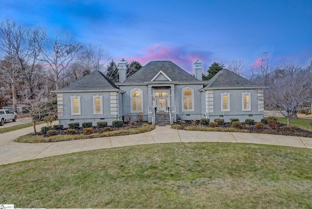 view of front of house with a shingled roof, a chimney, crawl space, a front yard, and stucco siding