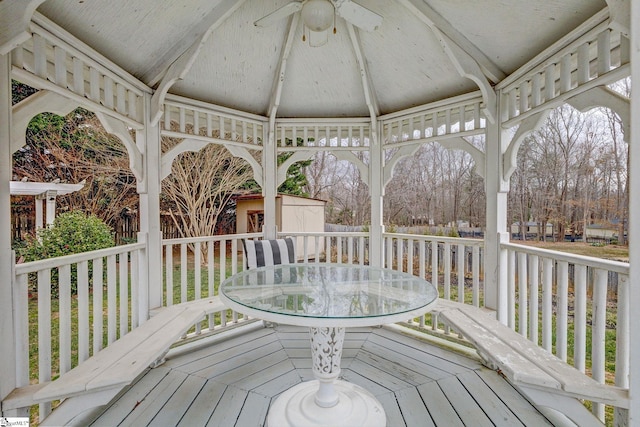 deck featuring outdoor dining space, an outdoor structure, a gazebo, and a storage unit