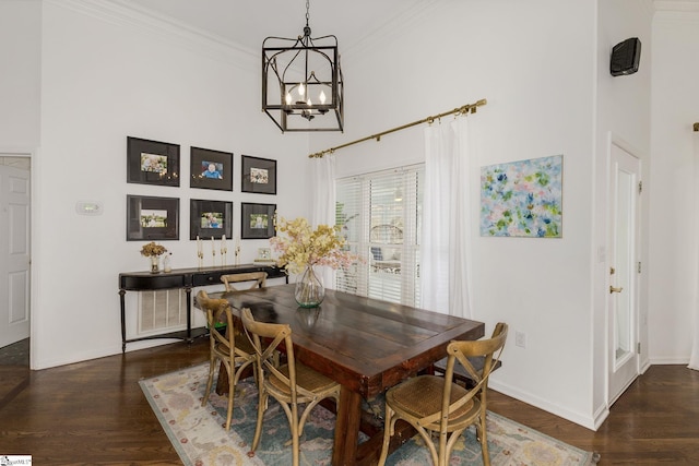 dining space featuring ornamental molding, wood finished floors, a high ceiling, and a notable chandelier