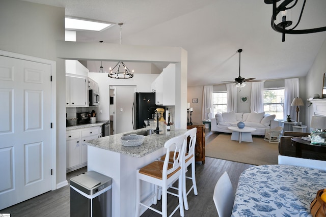 kitchen with dark wood-style floors, freestanding refrigerator, white cabinets, a sink, and range with electric cooktop