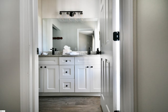 bathroom featuring double vanity and wood finished floors