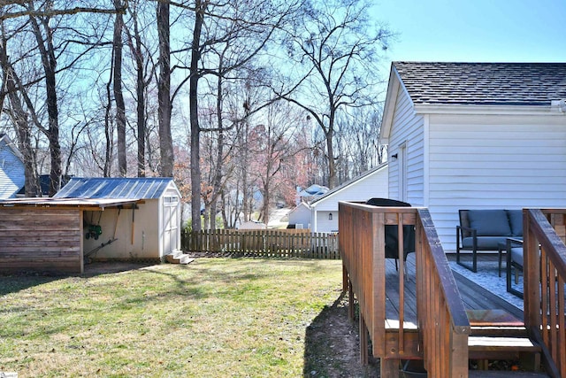 view of yard featuring an outbuilding, a shed, fence, and a wooden deck