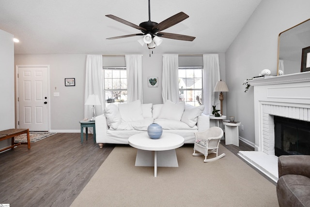 living room featuring plenty of natural light, a fireplace, baseboards, and wood finished floors