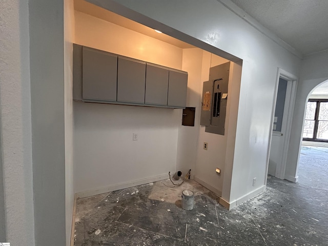 laundry room featuring arched walkways, laundry area, and electric panel