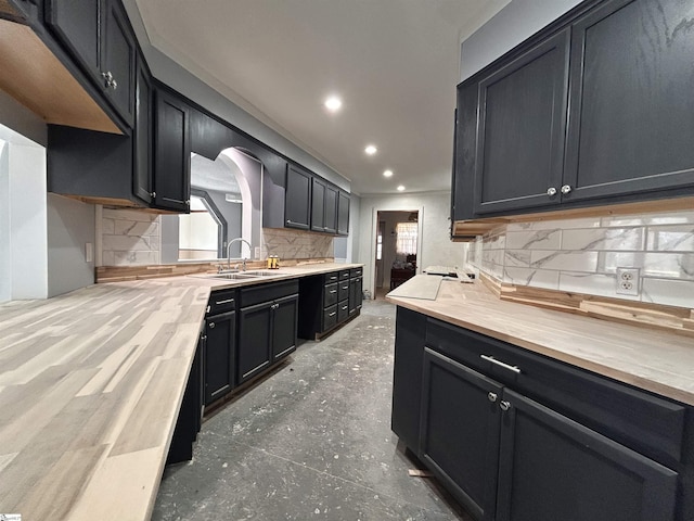 kitchen with recessed lighting, a sink, light countertops, a wealth of natural light, and decorative backsplash