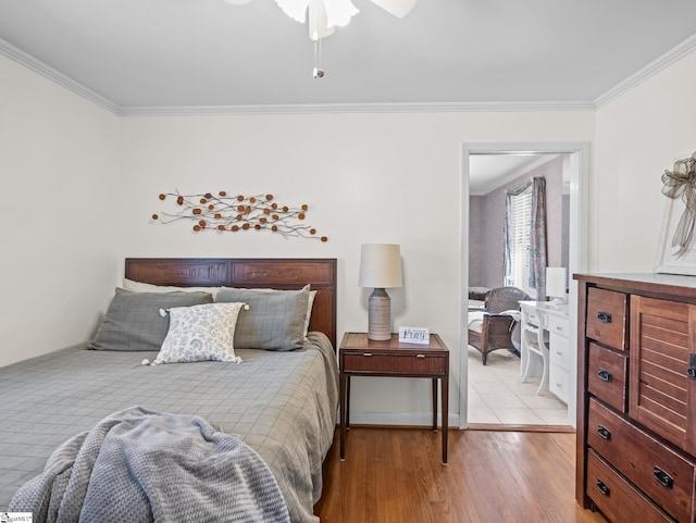 bedroom with light wood-style flooring, ornamental molding, and a ceiling fan