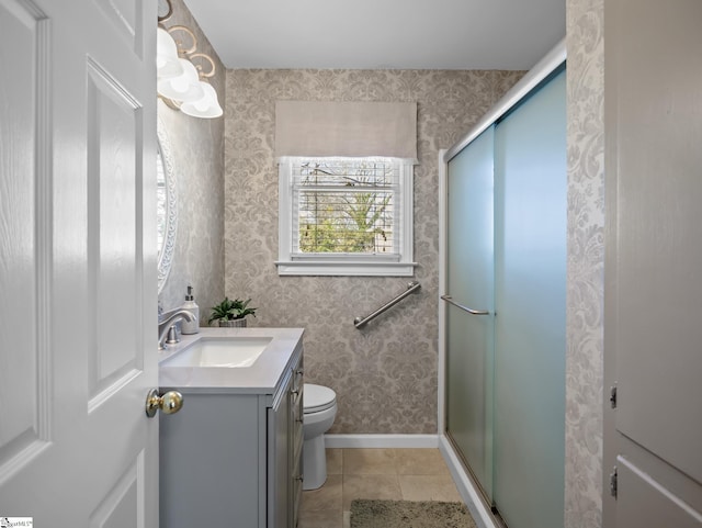 bathroom featuring toilet, wallpapered walls, a shower stall, and tile patterned floors