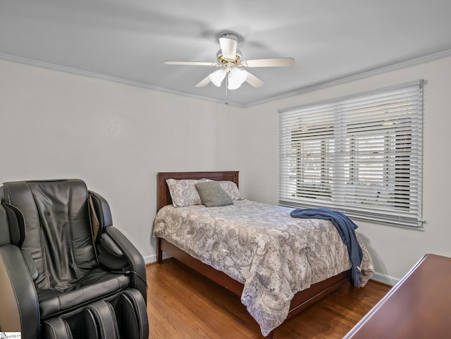 bedroom with ornamental molding, wood finished floors, and baseboards